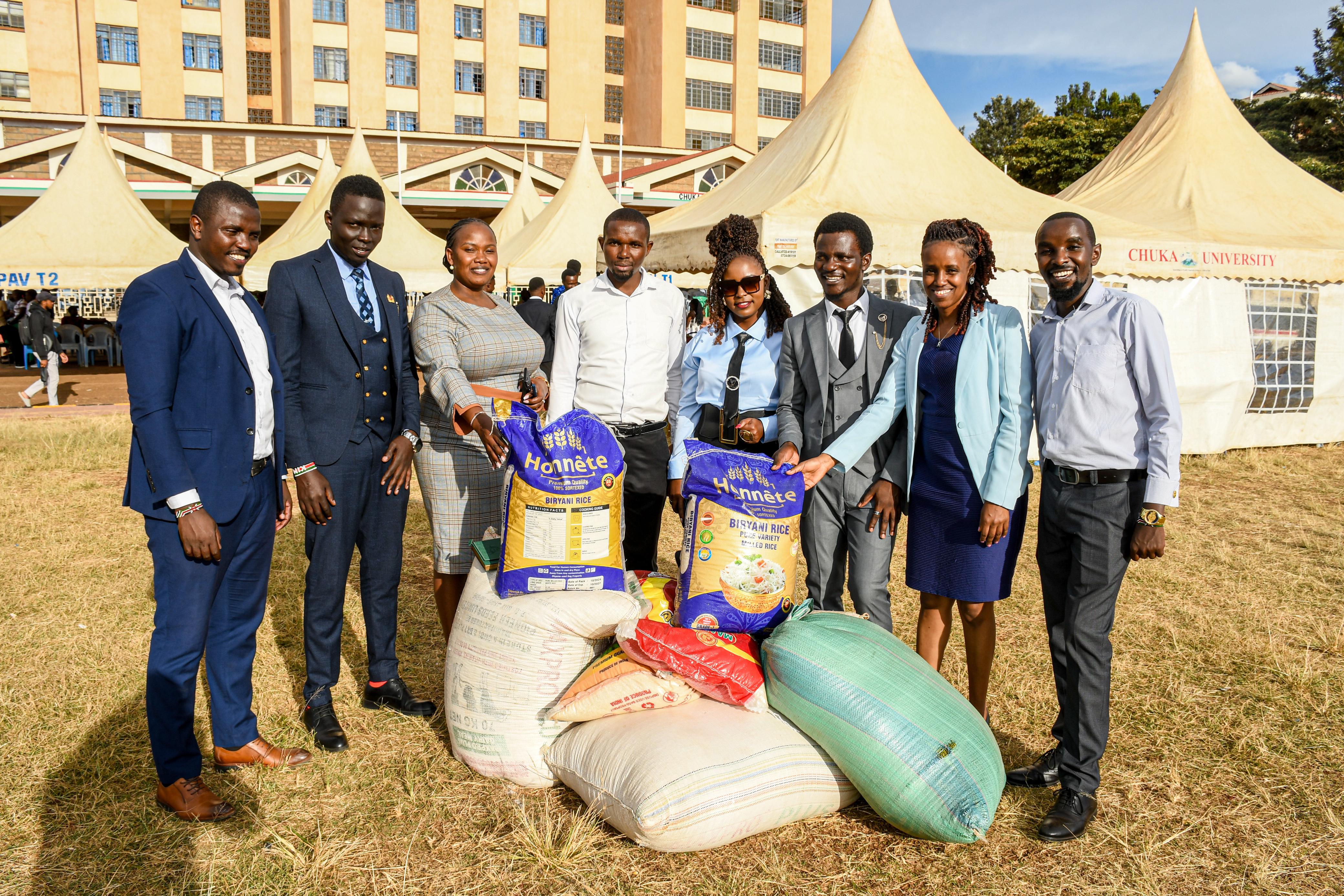Mr. Livan Njeru(Secretary General), Mr. Anthony Kimani(Treasurer), Ms. Lucy Wambui(Org. sec),and Mr. James Wainaina(Male Rep.) handing over cereals to the representatives of the office of the dean of students and the CUSA director welfare.