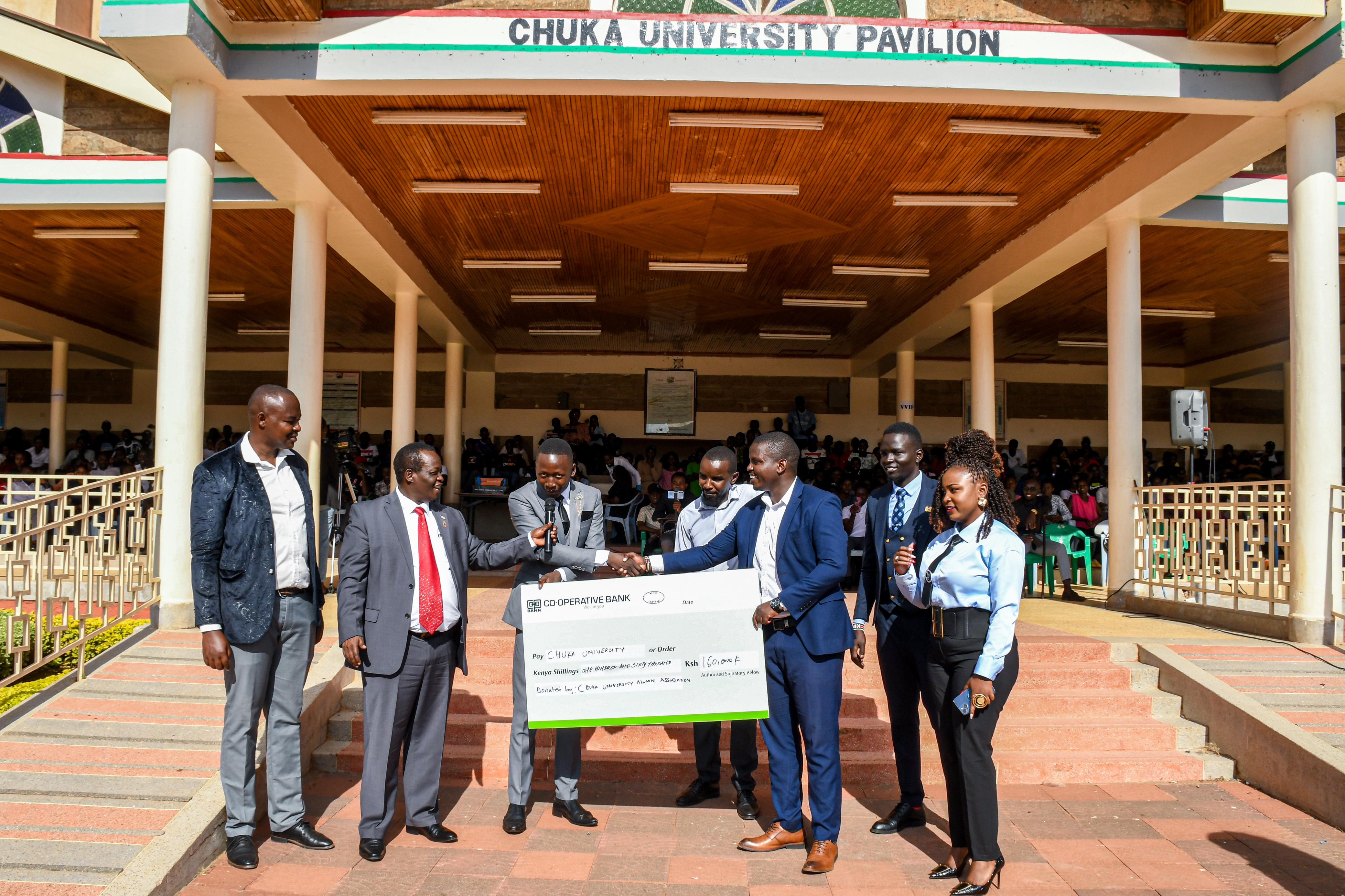 Mr. Livan Njeru(Secretary General), Mr. Anthony Kimani(Treasurer), Ms. Lucy Wambui(Org. sec), Mr. James Wainaina(Male Rep.), and Mr. Wilfred Rutto(Chapter coordinator) handing over the cheque to Prof. Mutembei(VC) and Mr. Ben Geoffrey(Cusa Chair)